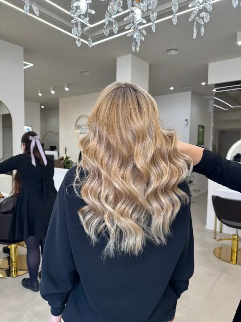 Capelli biondo Golden Sand con onde morbide, realizzati con il Metodo BROSS™ per un effetto naturale, luminoso ed elegante.