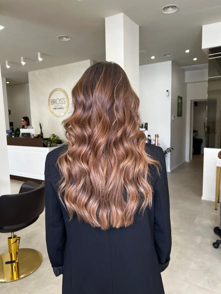 Capelli lunghi con schiariture caramello e onde morbide, realizzati con il Metodo BROSS™ per un effetto caldo, luminoso e naturale.