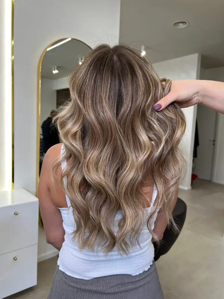 Capelli lunghi con schiaritura naturale biondo miele, onde morbide e look luminoso, realizzato nel BROSS Hair Lounge con il Metodo BROSS™.